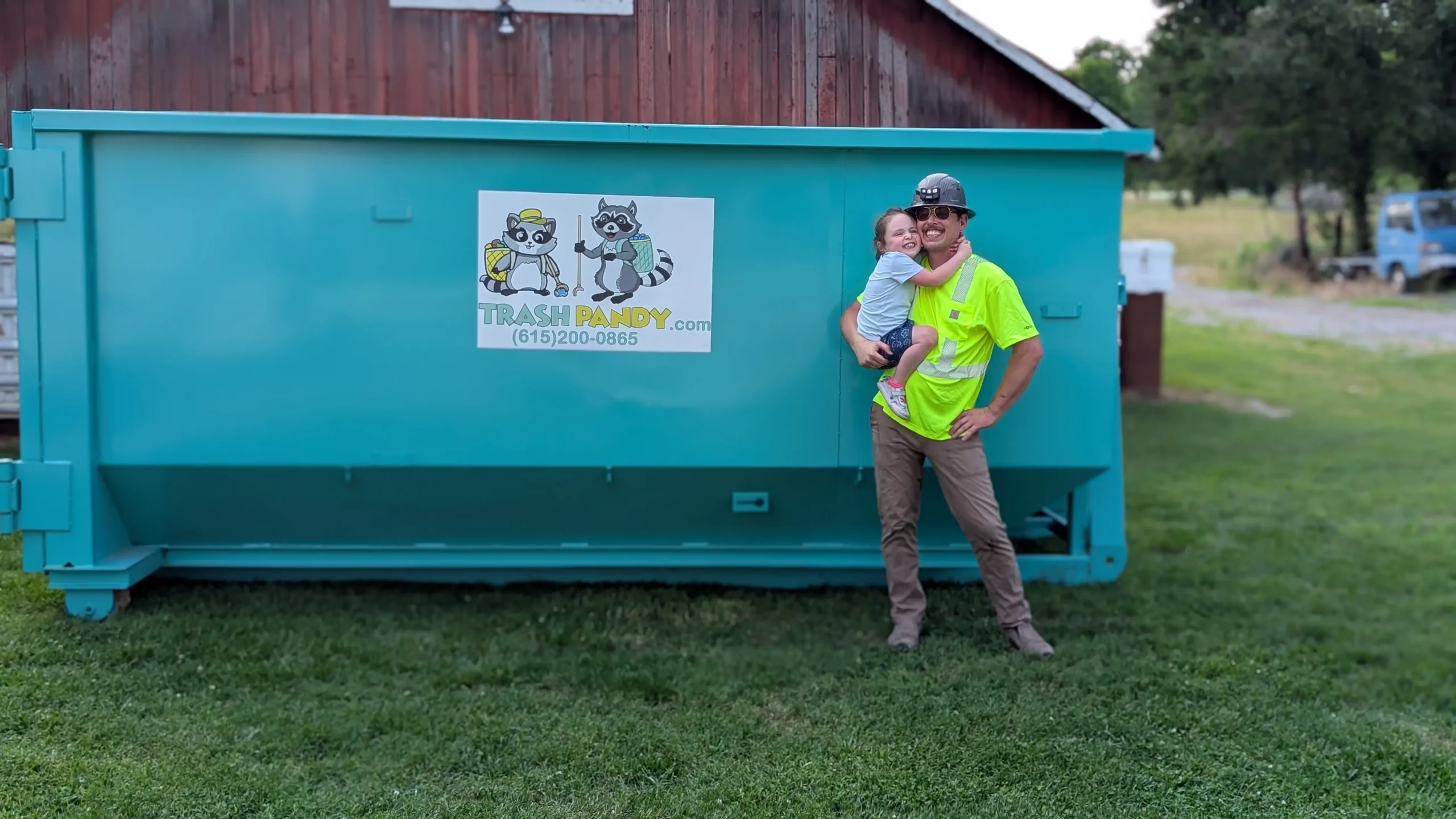 William Shackelford and his daughter beside a Trash Pandy roll off dumpster